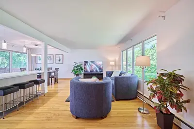a living room with two blue chairs and a bar at Chinook Executive Entire House in Calgary