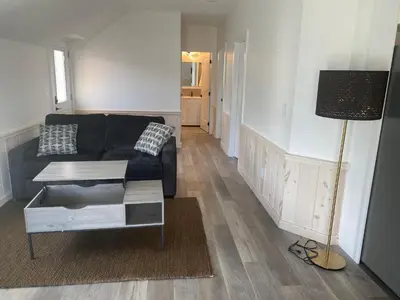 a living room with a black couch and a table at Lakeside Cottage in Nanaimo