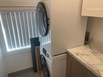 a washing machine in a kitchen with a window at Lakeside Cottage in Nanaimo