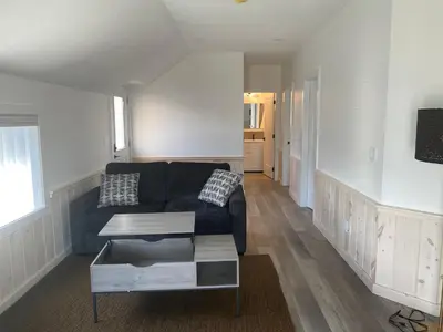 a living room with a black couch and a table at Lakeside Cottage in Nanaimo