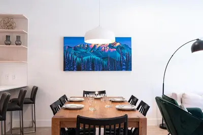 a dining room table with chairs and a lamp at Rustic Retreat by Revelstoke Vacations in Revelstoke