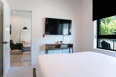 a bedroom with a bed and a tv on a wall at Rustic Retreat by Revelstoke Vacations in Revelstoke