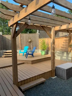 a wooden pergola with two chairs and a table on a deck at Best Bed and Breakfast in Port Alberni