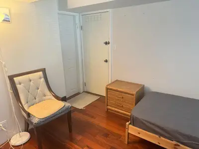 a bedroom with a bed and a chair and a dresser at Cozy and Friendly Home Single Room No Pets Allowed in Burnaby