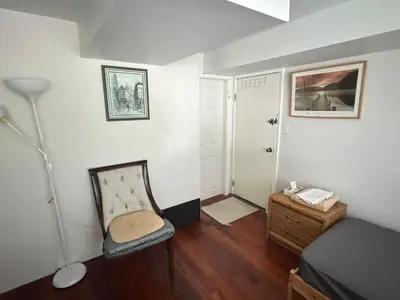 a room with a bed and a chair and a lamp at Cozy and Friendly Home Single Room No Pets Allowed in Burnaby