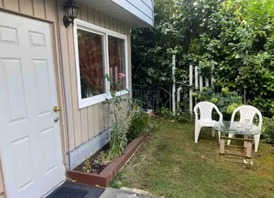 a pair of chairs sitting outside of a house at Cozy and Friendly Home Single Room No Pets Allowed in Burnaby