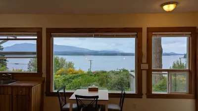 a kitchen with a table and a view of a lake at Seine Boat Inn in Alert Bay
