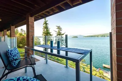 a table on a balcony with a view of the water at OCEAN FRONT 2 BEDROOM SUITE with STUNNING VIEWS in Victoria