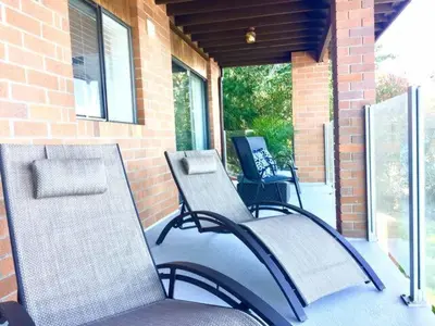 two chairs sitting on the porch of a house at OCEAN FRONT 2 BEDROOM SUITE with STUNNING VIEWS in Victoria