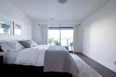a white bedroom with a bed and a large window at OCEAN FRONT 2 BEDROOM SUITE with STUNNING VIEWS in Victoria