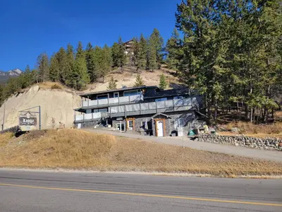 a house on the side of a hill with a road at WhiteTail Suite - Misty River Lodge - in Radium Hot Springs
