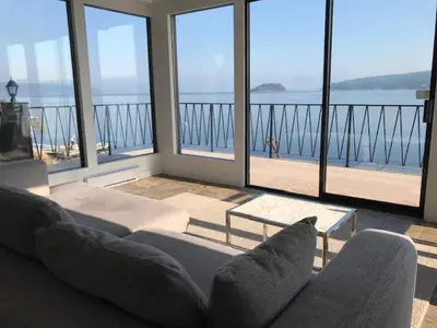 a living room with a couch and a view of the ocean at Ocean Front Retreat with Stunning Water Views in Victoria