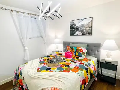 a bedroom with a bed with a colorful comforter at Langley Heights 2 Bedrooms Sweet Suite in Langley