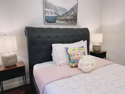 a bedroom with a bed with a black headboard and two lamps at Langley Heights 2 Bedrooms Sweet Suite in Langley
