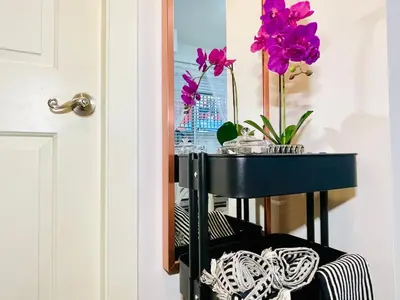 a black table with purple flowers in a mirror at Langley Heights 2 Bedrooms Sweet Suite in Langley