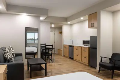 a kitchen and living room with a couch and a table at Baymont by Wyndham West Edmonton in Edmonton