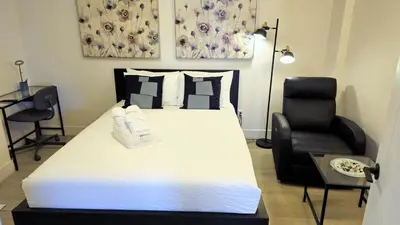 a bedroom with a large white bed and a chair at Cozy Retreat in Mission City