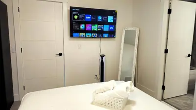 a bedroom with a bed and a tv on the wall at Cozy Retreat in Mission City