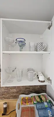 a shelf with bowls and other dishes on it at Cozy Retreat in Mission City