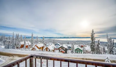 a village covered in snow with the sun in the background at Vista at Big White w Amazing Location and View in Big White