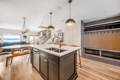 a kitchen and living room with a sink and a table at Vista at Big White w Amazing Location and View in Big White