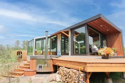 a small house with glass walls and a wooden deck at Refuge Bay Caelum Cabin Luxury Off Grid Escape in Cherhill