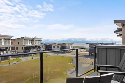 a balcony with a view of the beach and houses at Ocean View Townhouse #27 in Oyster Bay