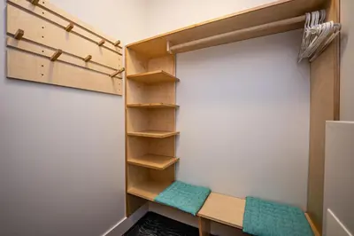 a walk in closet with a bench and shelves at Downunder Mountain Retreat in Revelstoke