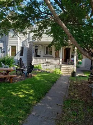a white house with a bench in the yard at Mission Historical Home in Calgary