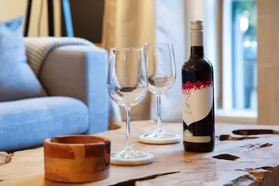 a bottle of wine and two wine glasses on a table at Glacier Lodge Premiere Suite in Whistler