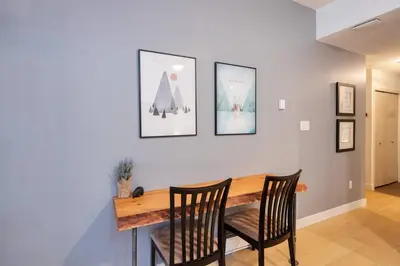 a dining room with a wooden table and two chairs at Glacier Lodge Premiere Suite in Whistler