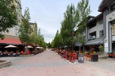 a street with tables and chairs in a city at Glacier Lodge Premiere Suite in Whistler