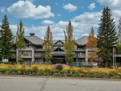 a large building with trees in front of it at Glacier Lodge Premiere Suite in Whistler