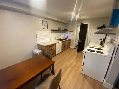 a kitchen with a table and a white refrigerator at Newly Renovated 1br1ba With Asian Style Tea Room in Edmonton