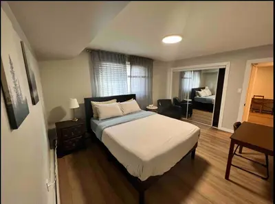 a bedroom with a bed and a living room at Guest Suite Close To Whtye Ave in Edmonton