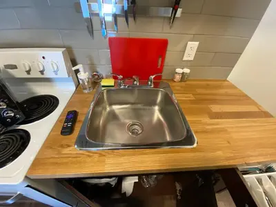 a kitchen counter with a sink and a stove at New Dt Apartment Walk To All in Edmonton