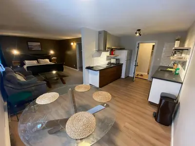 a living room with a glass table and a kitchen at Close To Whyte University New Renovation in Edmonton