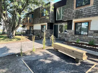 a wooden bench sitting in front of a building at Close To Whyte University New Renovation in Edmonton