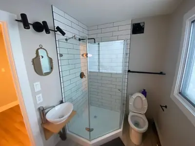 a bathroom with a shower and a toilet and a sink at Morden Newly Renovated 1br Flats, Walk To Whyte in Edmonton