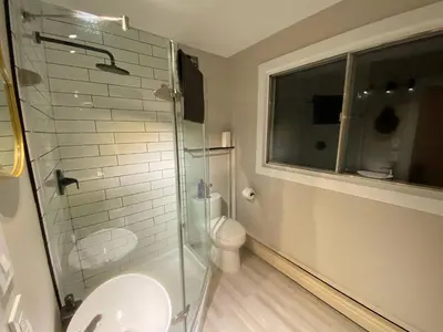 a bathroom with a toilet and a glass shower at Morden Newly Renovated 1br Flats, Walk To Whyte in Edmonton