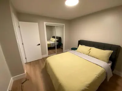 a bedroom with a large bed and a room with a bed sqor at Central 2br Near Unveristy And Whyte Ave in Edmonton