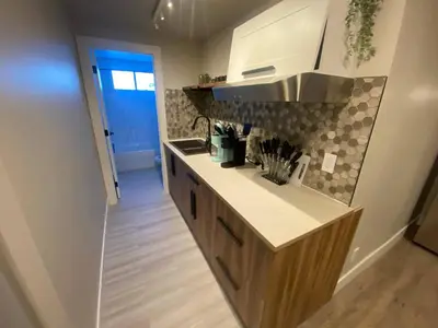 a kitchen with a sink and a counter top at Brand New Modern Flat 2br1ba Whyte And University in Edmonton