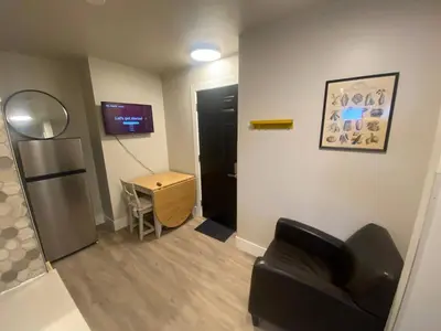 a living room with a black couch and a table at Brand New Modern Flat 2br1ba Whyte And University in Edmonton