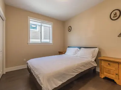 a bedroom with a bed and a window at \u6d77\u5c9b\u6c11\u5bbf 3\u5f20\u5e8a-2\u95f4\u5367\u5ba4\u72ec\u7acb\u5957\u623f in Nanaimo