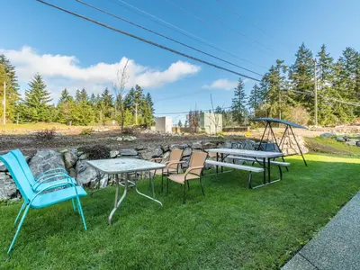 a yard with chairs and tables and a swing at \u6d77\u5c9b\u6c11\u5bbf 3\u5f20\u5e8a-2\u95f4\u5367\u5ba4\u72ec\u7acb\u5957\u623f in Nanaimo