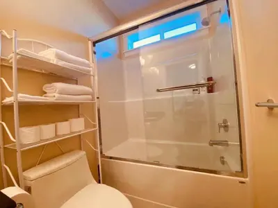 a bathroom with a shower with a toilet and towels at \u6d77\u5c9b\u6c11\u5bbf 3\u5f20\u5e8a-2\u95f4\u5367\u5ba4\u72ec\u7acb\u5957\u623f in Nanaimo