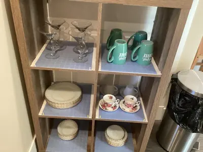 a wooden shelf with dishes and cups and glasses at \u6d77\u5c9b\u6c11\u5bbf 3\u5f20\u5e8a-2\u95f4\u5367\u5ba4\u72ec\u7acb\u5957\u623f in Nanaimo