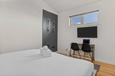 a white bedroom with a bed and two chairs at Freshly Remodeled - 2 King Beds- Breathtaking Views in Canmore