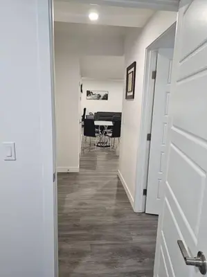 a hallway leading to a dining room with a table at New 2 bdrm basement suite Seton in Calgary