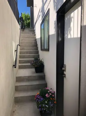 a stairway with a door and some plants and flowers at Modern luxury and convenience in Marda Loop in Calgary